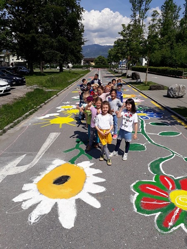Eine Gruppe Kinder posiert auf der Straße mit ihren gemalten Blüten