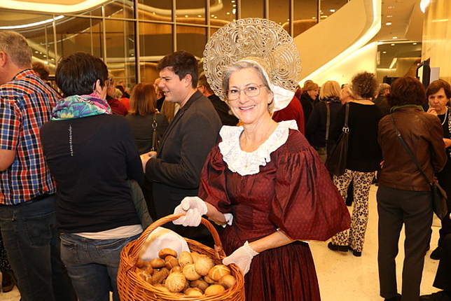 Eine Dame des Trachtenvereins in ihrer Tracht, sie hält einen Korb mit Brot in den Händen.