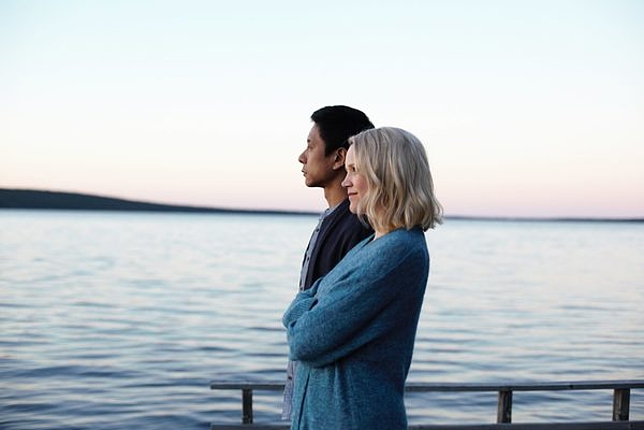Eine Frau und ein Herr stehen auf einem Steg und blicken aufs Meer.