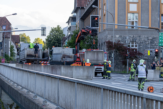 Feuerwehrmänner und die Firma Bickel beim Aufstellen der Betonelemente auf der Illbrücke. 