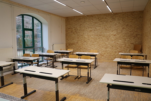 Ein Klassenzimmer in den Werkstätten, mit Stühlen und Schulbänken.