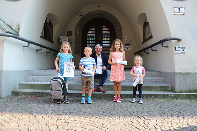 Bürgermeister Matt mit den vier Gewinnerinnen und Gewinnern der Kinderstadtrallye vor dem Rathaus.