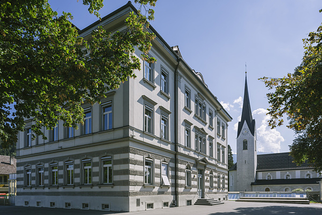 Volksschule Sebastianplatz von außen, im Hintergrund der Kirchturm