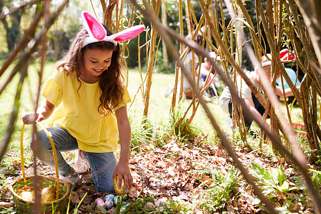 Mädchen im Garten sammelt Ostereier