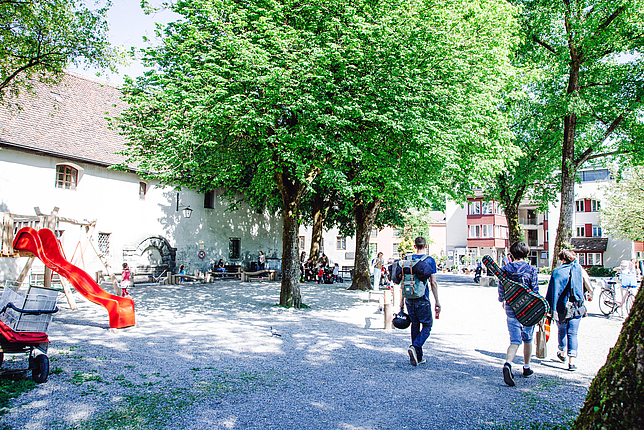 Spielplatz Elisabethplatz in der Innenstadt von Feldkirch mit Personen im Vorübergehen