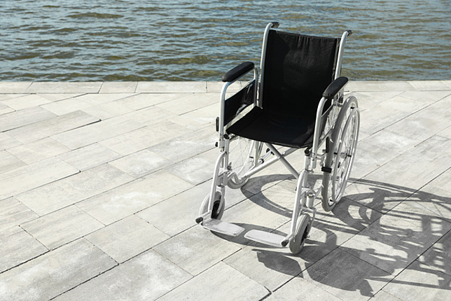 Ansicht von einem schwarzen Rollstuhl vor Wasser