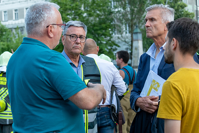 Bürgermeister Wolfgang Matt, Stadtbaumeister Gabor Mödlagl und Katastrophenschutzbeauftragter Josef Fröhlich stehen im Kreis und unterhalten sich. 