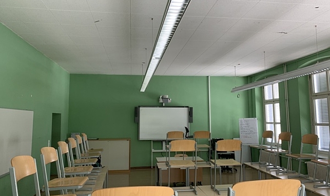 Ein Klassenzimmer der Polytechnischen Schule von innen. Stühle stehen auf den Schulbänken.