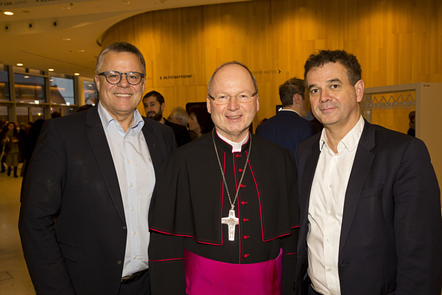 Bischof Benno Elbs posiert mit zwei Gästen für ein Foto