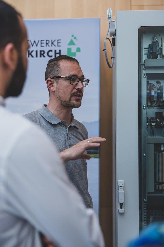 Ein Mitarbeiter der Stadtwerke Feldkirch im Gespräch mit Besuchern beim Informationsstand der Stadtwerke Feldkirch.