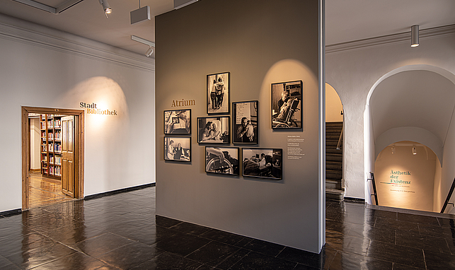 Raum im Palais Liechtnstein, an einer Wand hängen eingerahmte Fotos von älteren Menschen