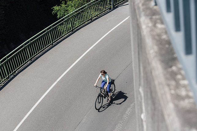 Frau in Feldkirch mit Fahrrad unterwegs.
