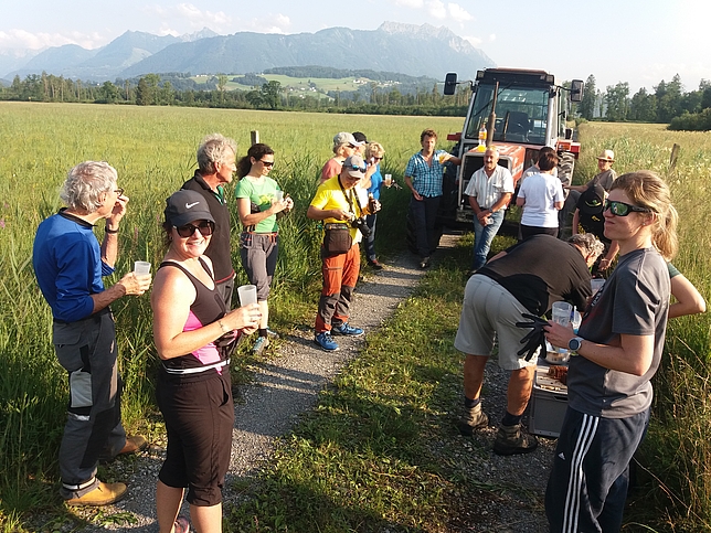 Eine Gruppe von Menschen steht mit Getränken auf einem Kiesweg im Europaschutzgebiet Bangs-Matschels. 