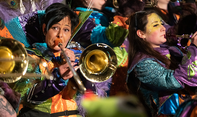 Eine Frau einer "Guggamusik-Truppe" spielt kostümiert Trompete.