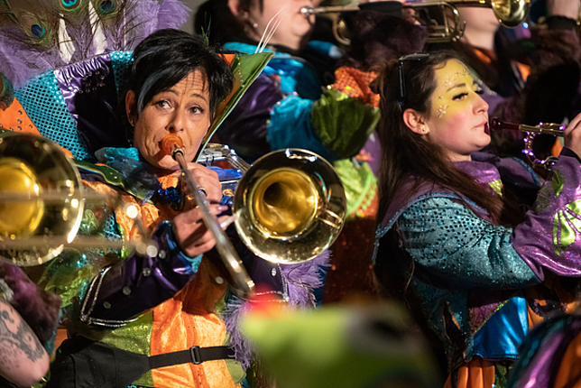 Eine Frau einer "Guggamusik-Truppe" spielt kostümiert Trompete.