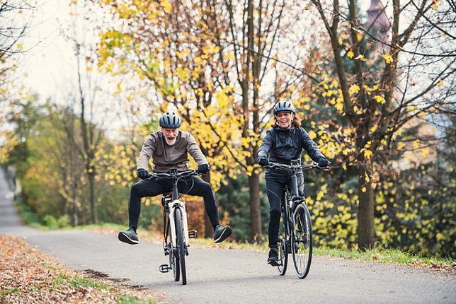Ein älteres Paar hat Spaß beim Radfahren durch den Wald. 
