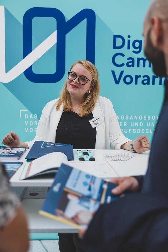Eine Mitarbeiterin des Digital Campus Vorarlberg beim Informationsstand. 