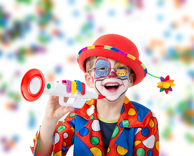 Junger Clown mit Spielzeugtrompete