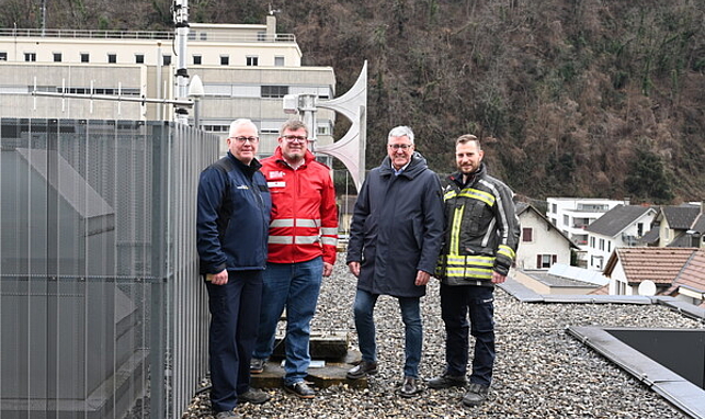 Josef Fröhlich (Katastrophenschutzbeauftragter), Christoph Kaar (Rotes Kreuz), Bürgermeister Wolfgang Matt und Marcel Frick (Feuerwehr Altenstadt) stehen auf dem Dach der Rettungsabteilung neben der neuen Sirene.