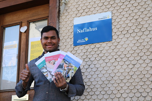 Fiaz Ahmed steht vor dem Naflahus mit einigen Broschüren in den Händen. 