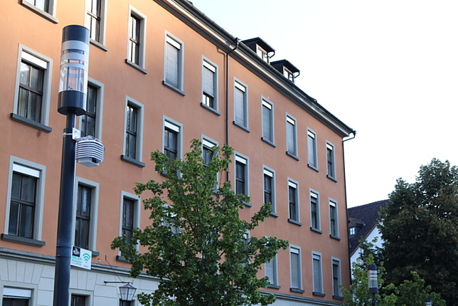 Das Pädagogische Förderzentrum in Feldkirch von außen, vor dem PFZ steht eine Straßenlaterne, an der eine Mess-Station angebracht wurde.